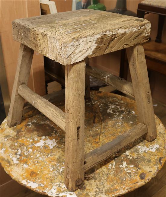 A rustic stool on four splayed legs Width of base 53cm